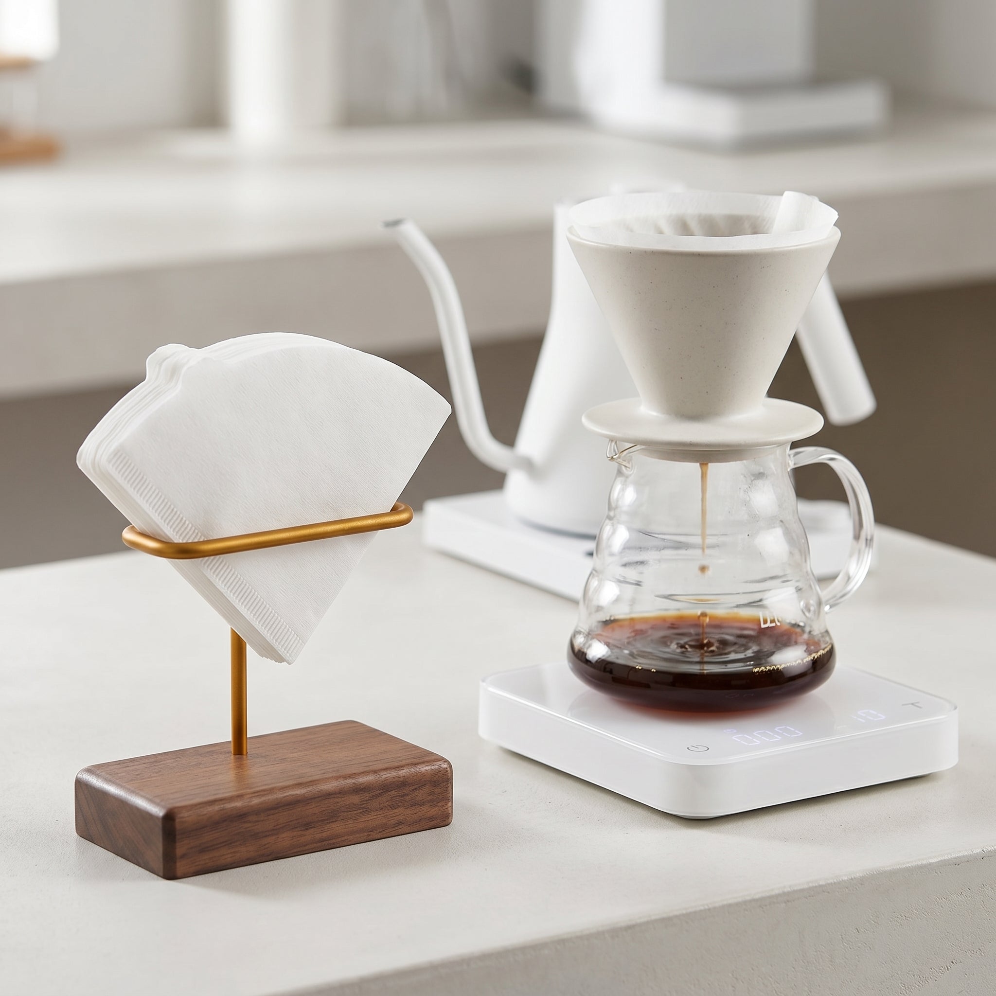 A bright slow-bar station featuring the Gable walnut filter stand next to a minimalist white gooseneck kettle and a glass carafe extracting fresh coffee.