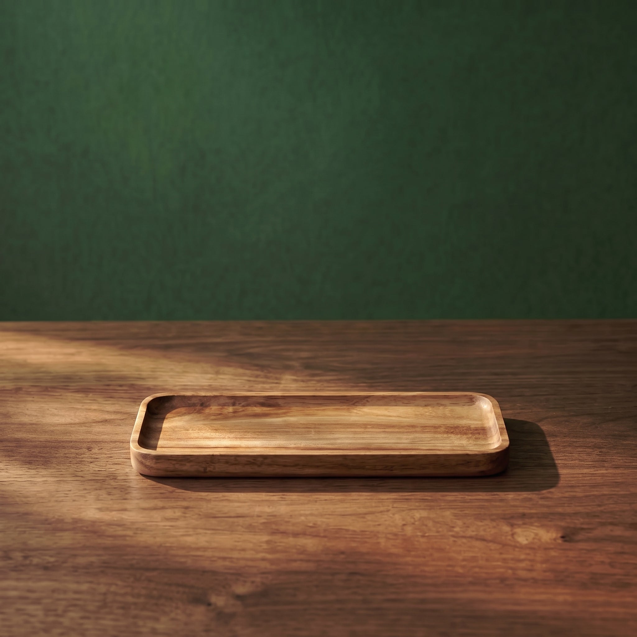 Small Vance beveled walnut wood tray displayed on a wooden tabletop against a textured dark green background, showcasing its slim profile for cafe or restaurant service.